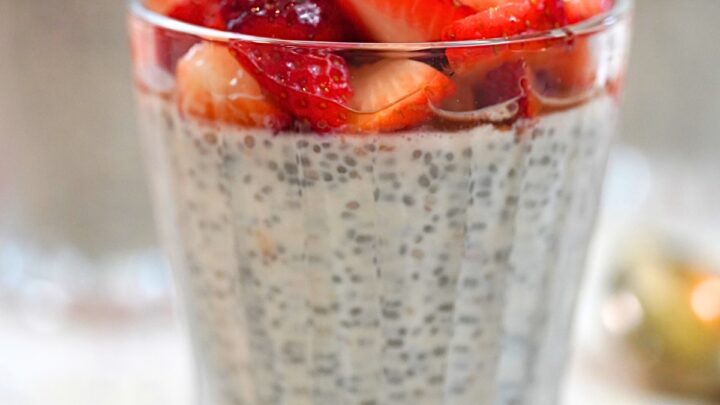 strawberry yogurt chia pudding with fresh strawberry topping in a glass cup