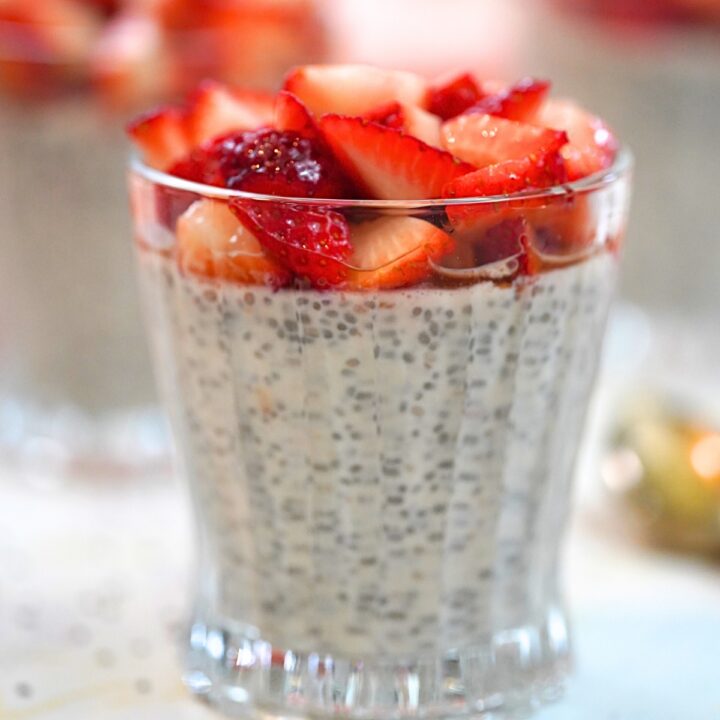 strawberry yogurt chia pudding with fresh strawberry topping in a glass cup