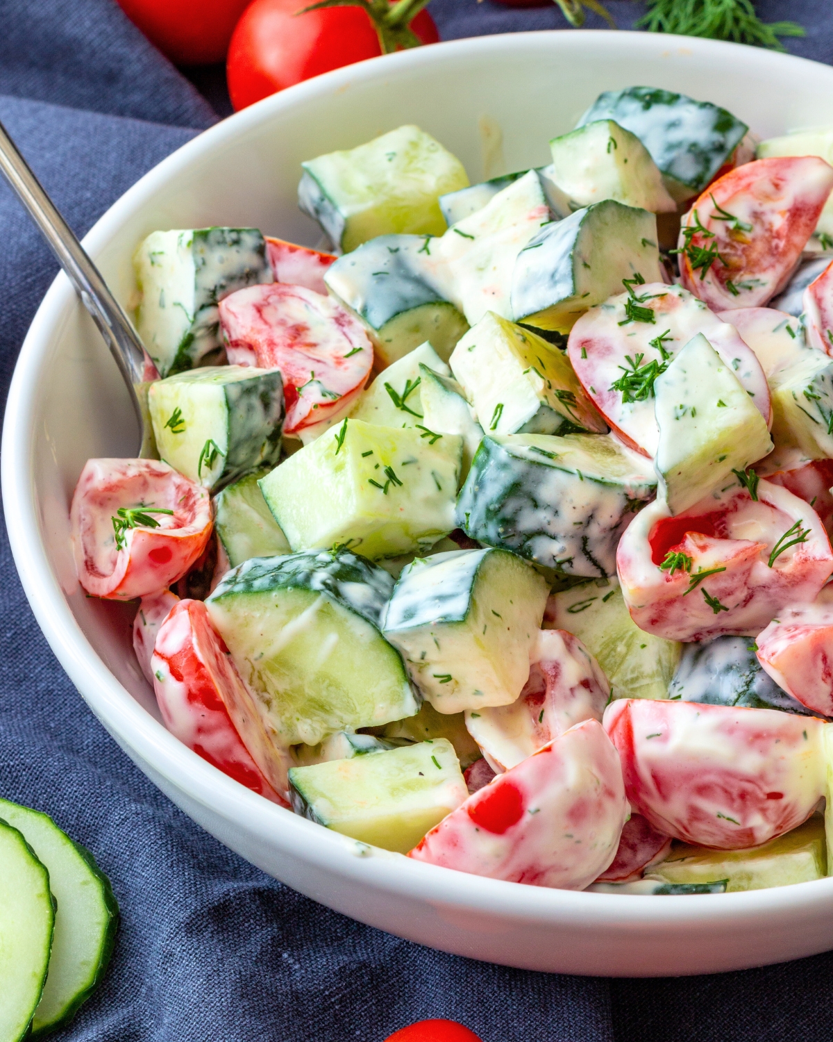 Tomato Cucumber Salad with Creamy Dill Dressing in a white bowl