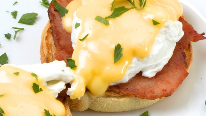 Easy Eggs Benedict - poached eggs with bacon and hollandaise sauce on a white plate