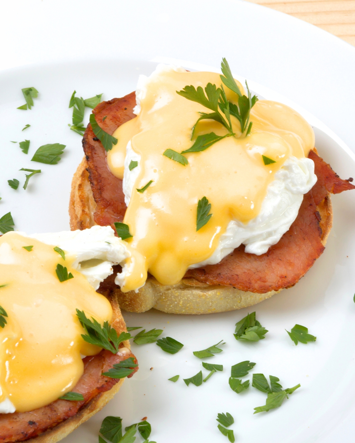 Easy Eggs Benedict - poached eggs with bacon and hollandaise sauce on a white plate