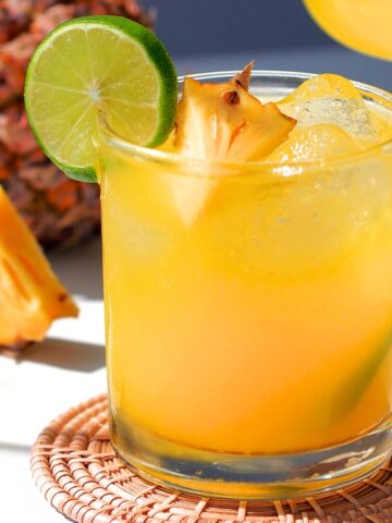 pineapple apricot mocktail in a short glass with lime and pineapple garnish