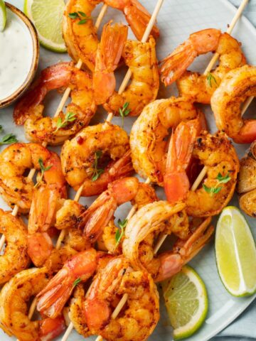 a plate of grilled shrimp skewers with citrus and garlic marinade