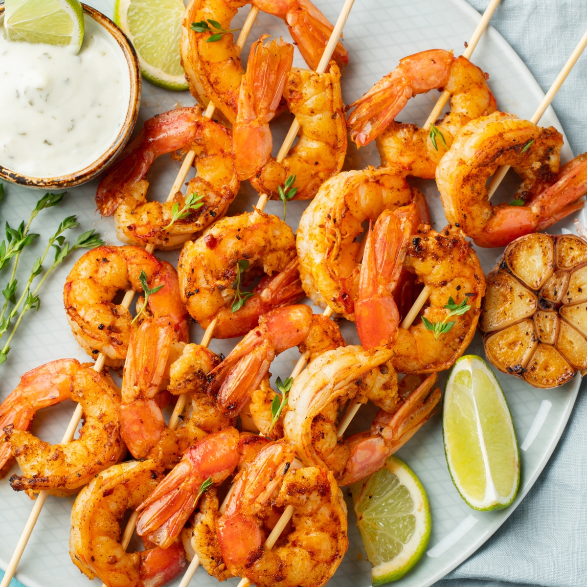 a plate of grilled shrimp skewers with citrus and garlic marinade