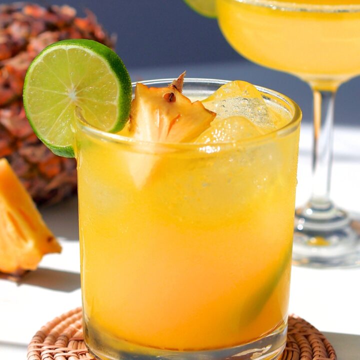 pineapple apricot mocktail in a short glass with lime and pineapple garnish