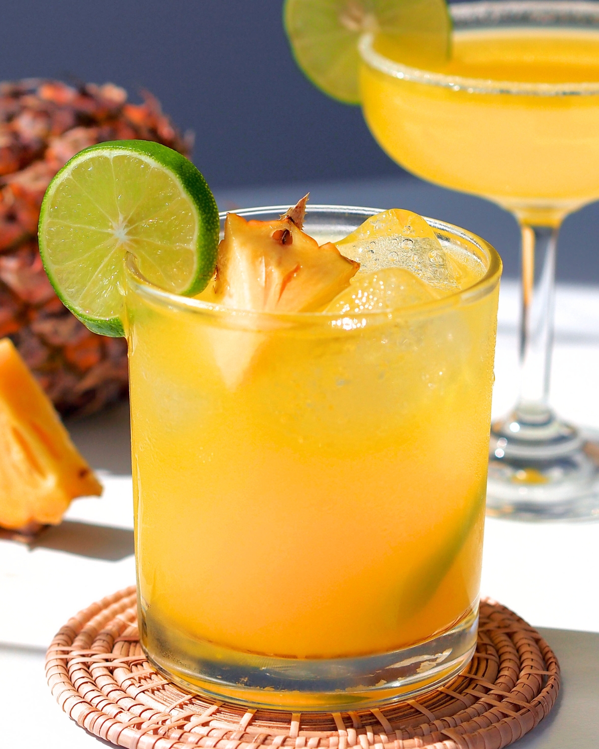 pineapple apricot mocktail in a short glass with lime and pineapple garnish