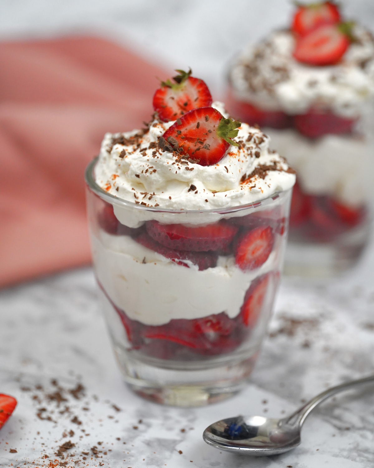 keto strawberry trifle in a glass with strawberry and shaved chocolate topping