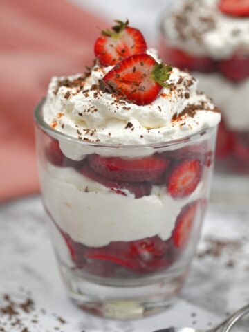 keto strawberry trifle in a glass with strawberry and shaved chocolate topping