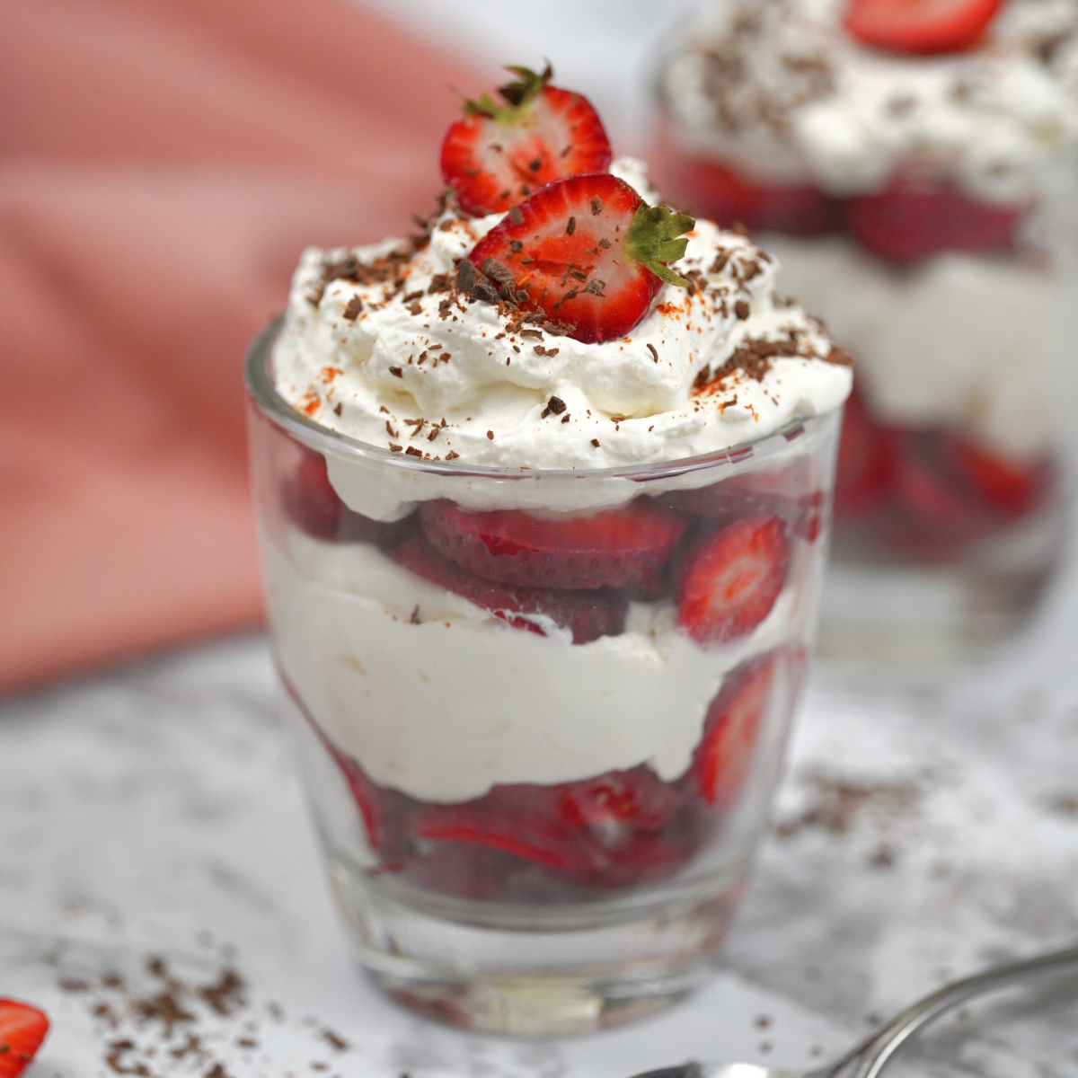 keto strawberry trifle in a glass with strawberry and shaved chocolate topping