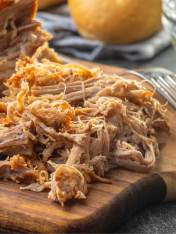 slow cooker pulled pork on a wooden board