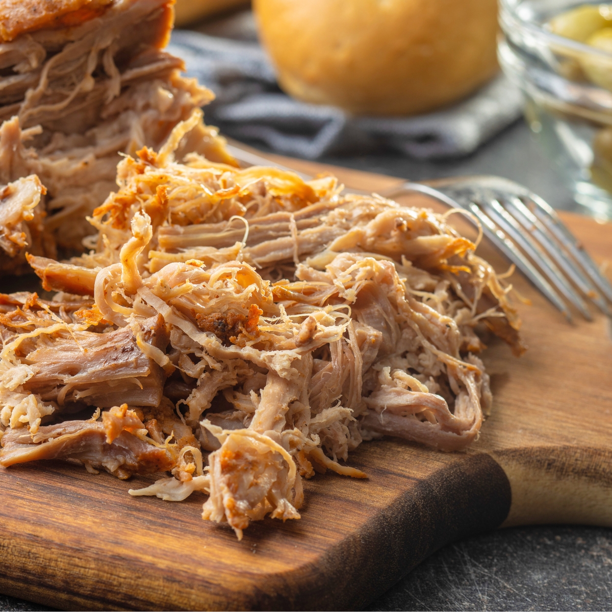 slow cooker pulled pork on a wooden board