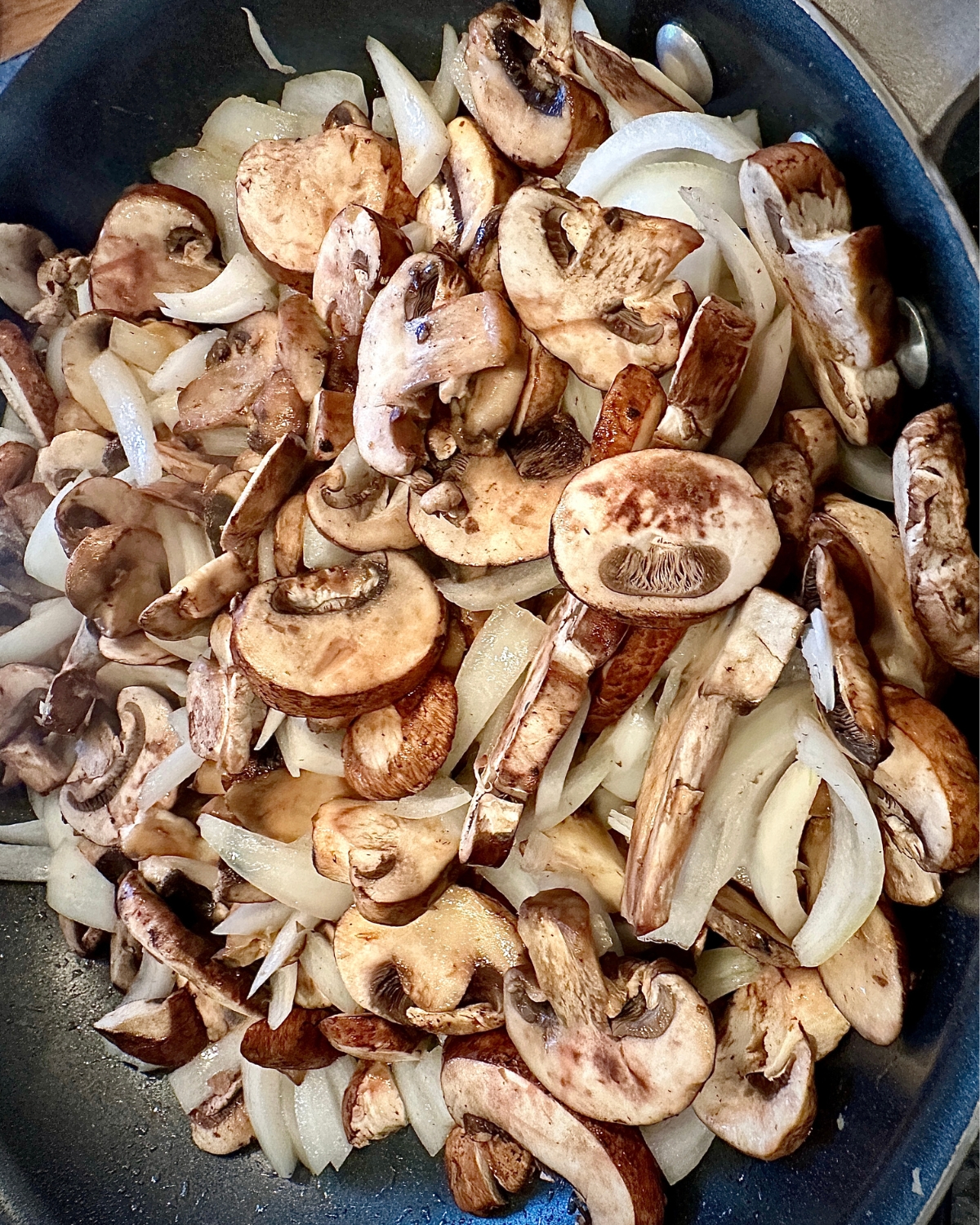 raw sauteed mushrooms and onions mix in a pan