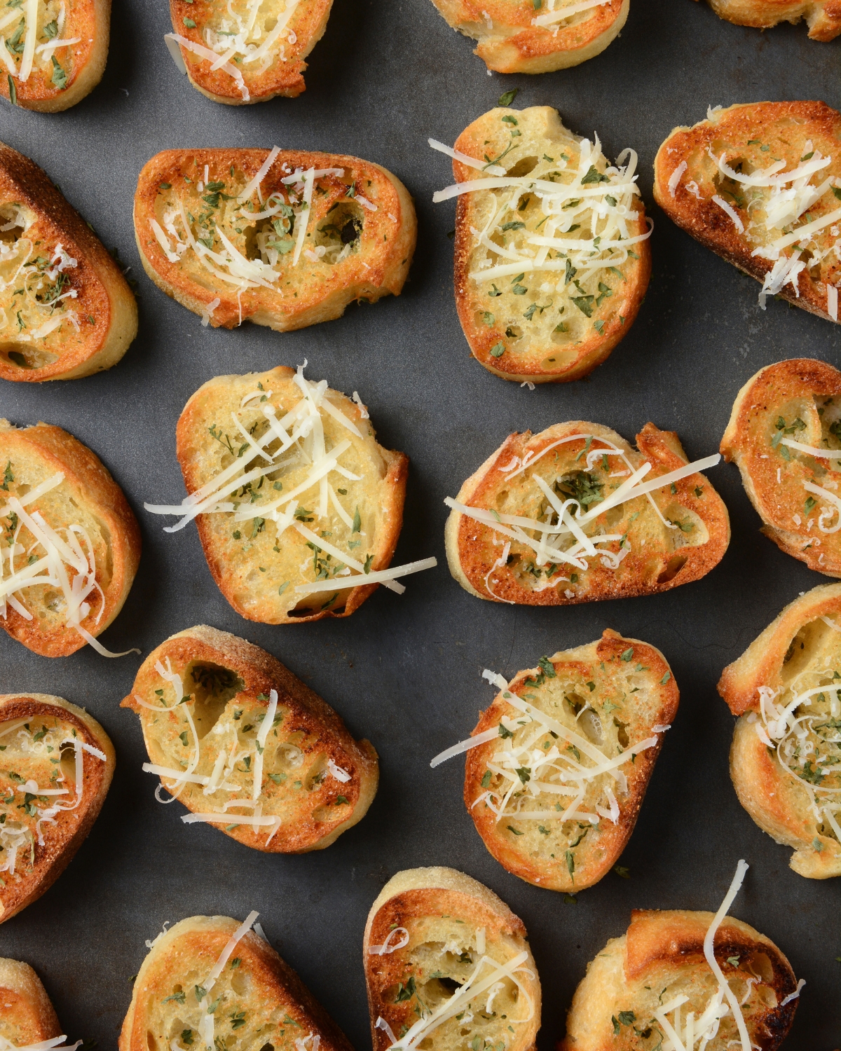 seasoned crostini slices on a baking sheet