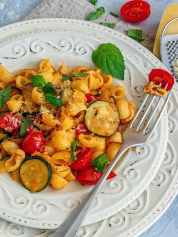 summer tomato zucchini pasta in a white plate