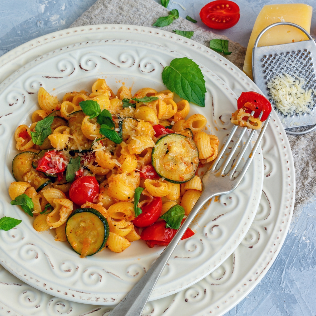 summer tomato zucchini pasta in a white plate