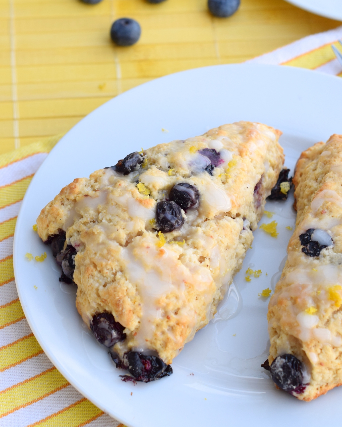 The Best Blueberry Lemon Scones with Lemon Icing on a white plate