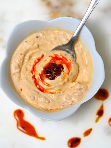 chili crunch sour cream taco sauce in a white bowl