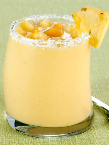 Coconut Mango Pineapple Smoothie with a green background