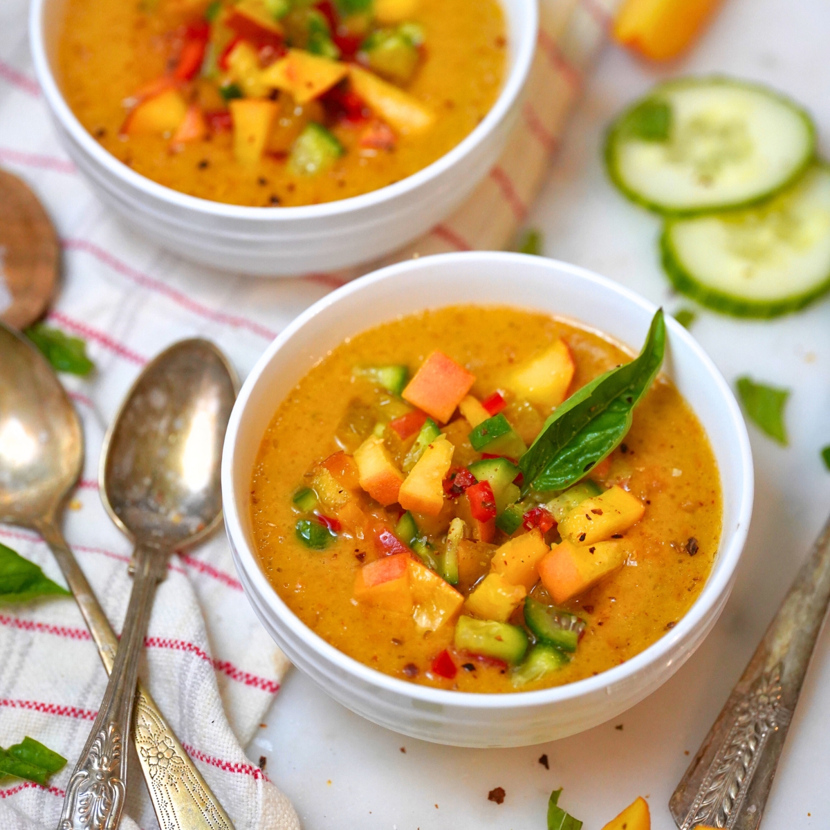 refreshing peach gazpacho in a white bowl