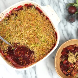 Plum Crisp with Pistachio Oat Crumble in a baking dish