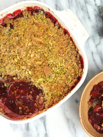 Plum Crisp with Pistachio Oat Crumble in a baking dish