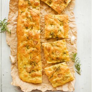 sliced roasted garlic focaccia on brown parchment paper