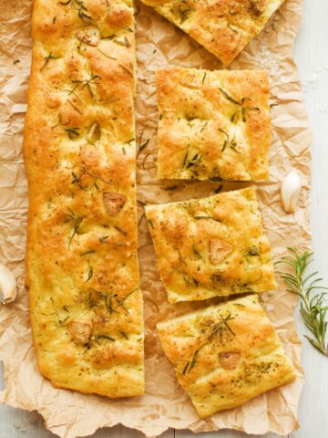 sliced roasted garlic focaccia on brown parchment paper