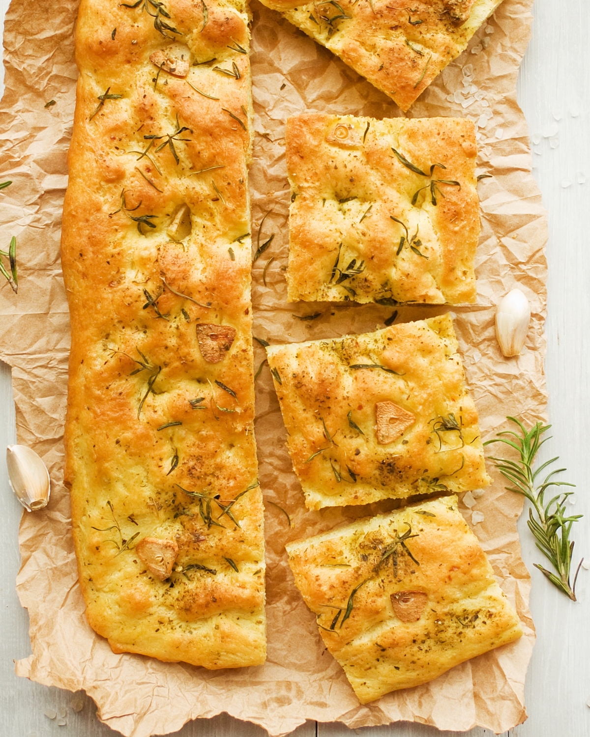 sliced roasted garlic focaccia on brown parchment paper