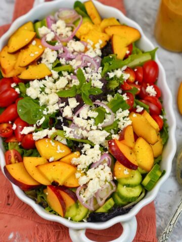 fresh summer peach salad in a white bowl