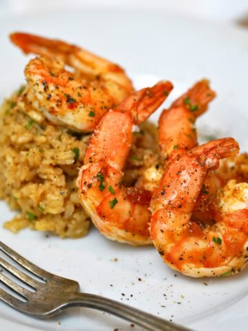 apricot glazed shrimp on a white plate with a side of rice