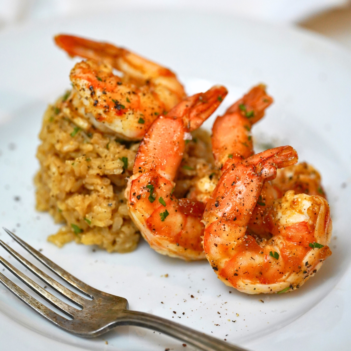 apricot glazed shrimp on a white plate with a side of rice