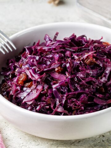 Braised Red Cabbage in a white bowl with a fork