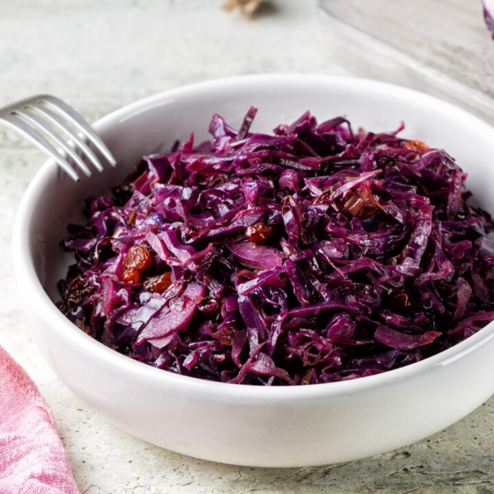 Braised Red Cabbage in a white bowl with a fork