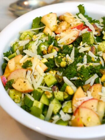 kale and apple salad in a white bowl