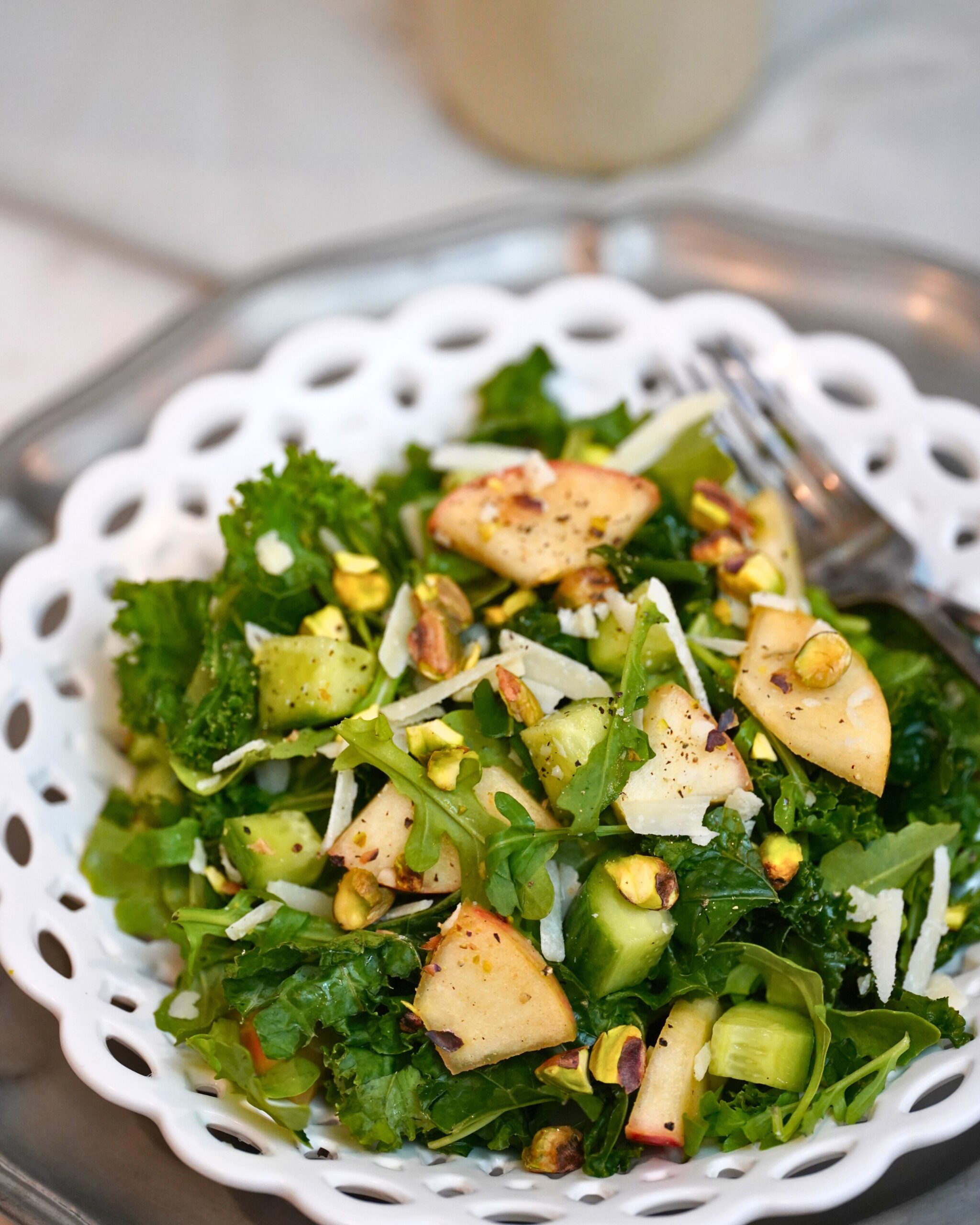 kale and apple salad in a white bowl