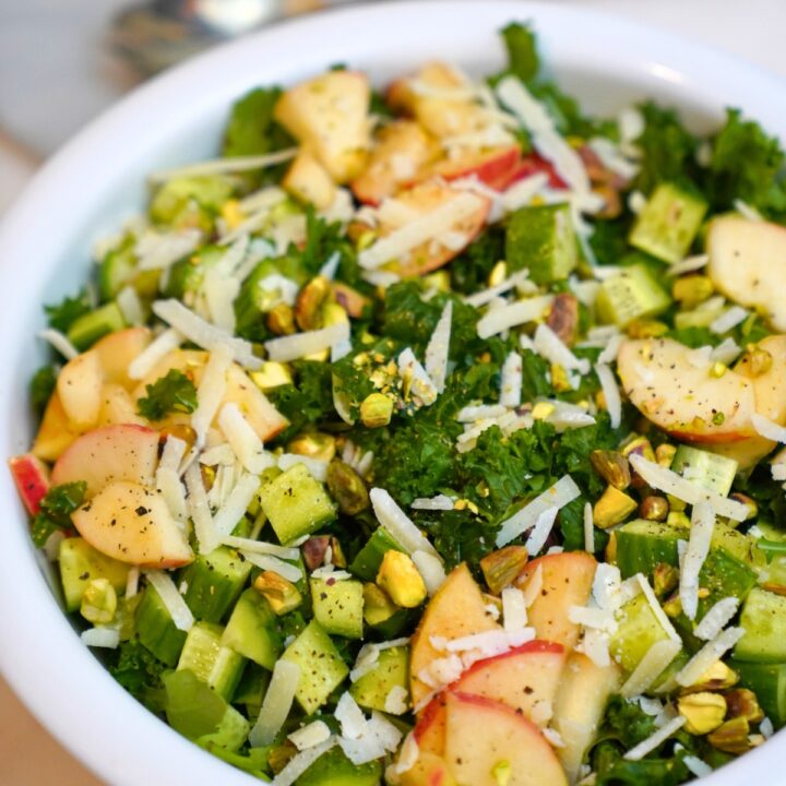 kale and apple salad in a white bowl