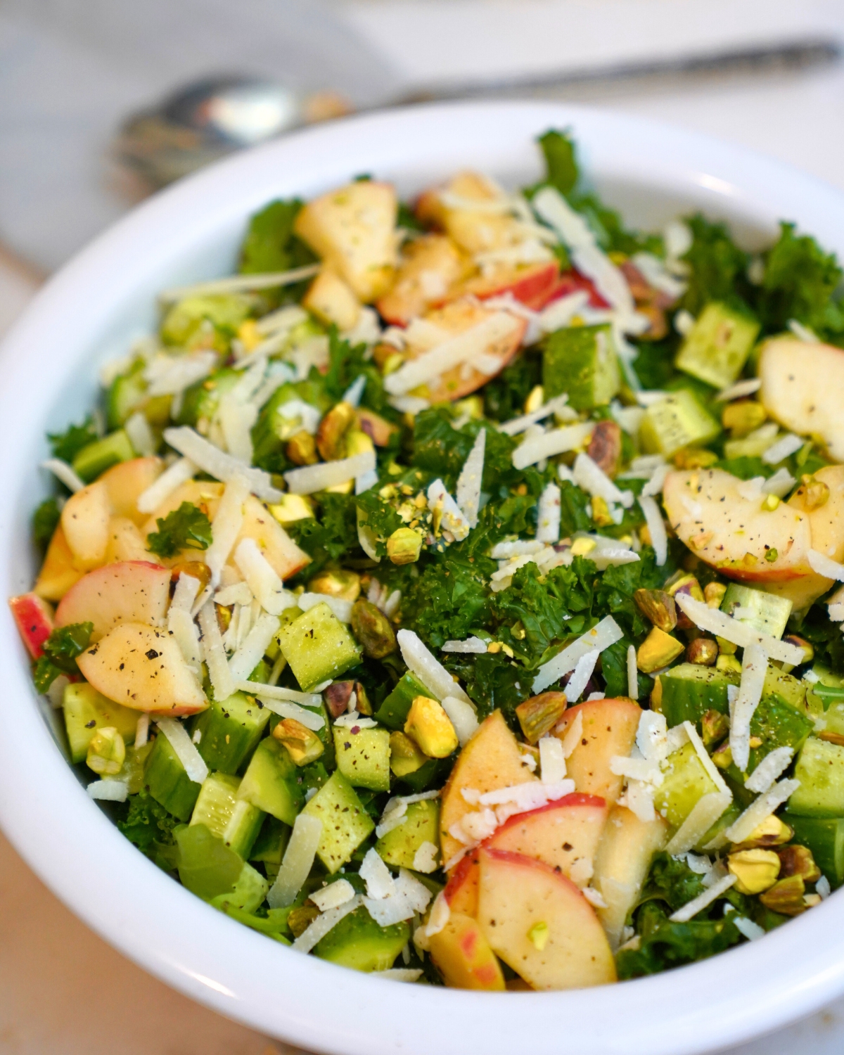 kale and apple salad in a white bowl